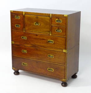 An early / mid 19thC mahogany campaign chest with brass caps and corner mounts, the chest comprising