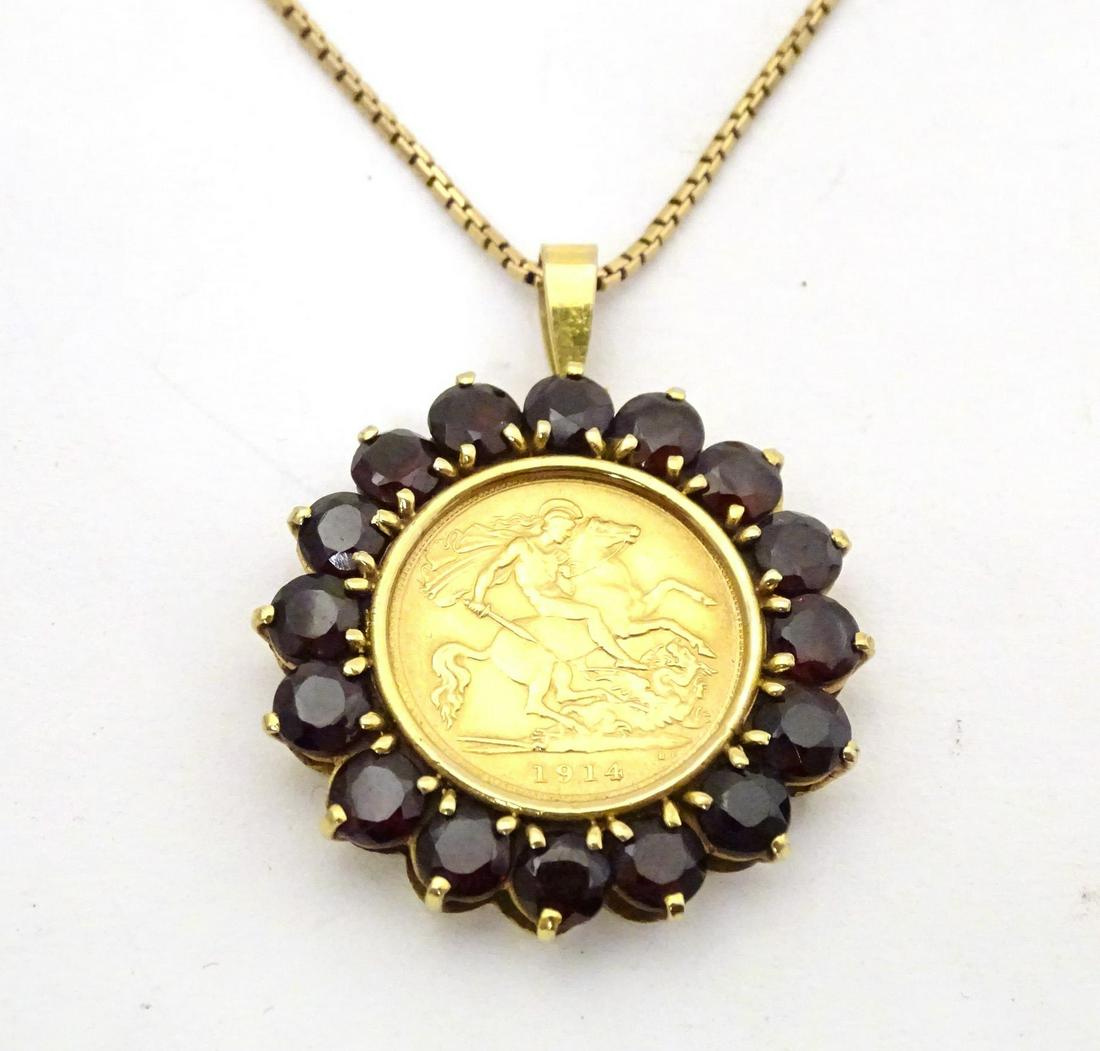 A 1914 half sovereign coin within a 9ct gold pendant mount bordered by garnets, on a 9ct gold chain.: A 1914 half sovereign coin within a 9ct gold pendant mount bordered by garnets, on a 9ct gold chain. Chain approx. 20" long, pendant approx. 1 3/4" long overall