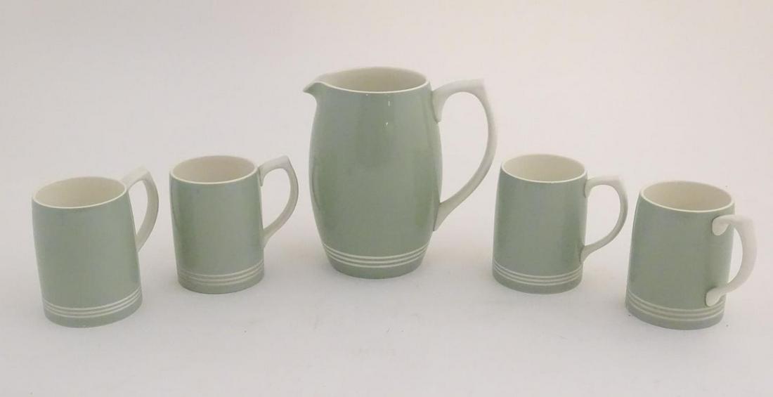A mid 20thC Keith Murray Wedgwood lemonade / beer set, comprising a moonstone jug and four tankards,: A mid 20thC Keith Murray Wedgwood lemonade / beer set, comprising a moonstone jug and four tankards, with a celadon glaze with cream banded decoration. Jug approx. Marked under. 8 1/4" high. (5)