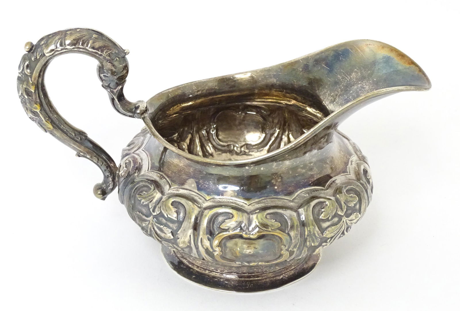 A 19thC Irish silver cream jug with embossed floral and foliate decoration, hallmarked Dublin 1837,: A 19thC Irish silver cream jug with embossed floral and foliate decoration, hallmarked Dublin 1837, maker Robert W. Smith. Approx. 4 1/2" high x 7" wide