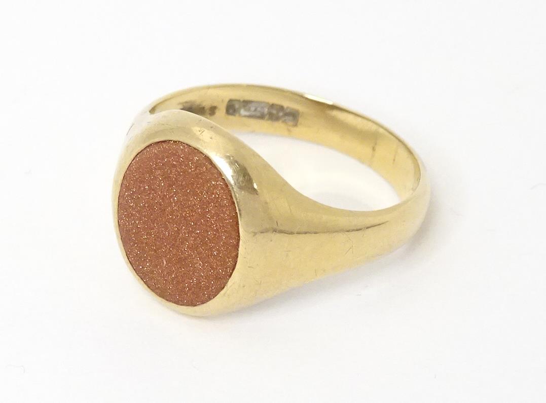 A 9ct gold signet ring set with goldstone. Ring size approx T 1/2 (1 of 8)