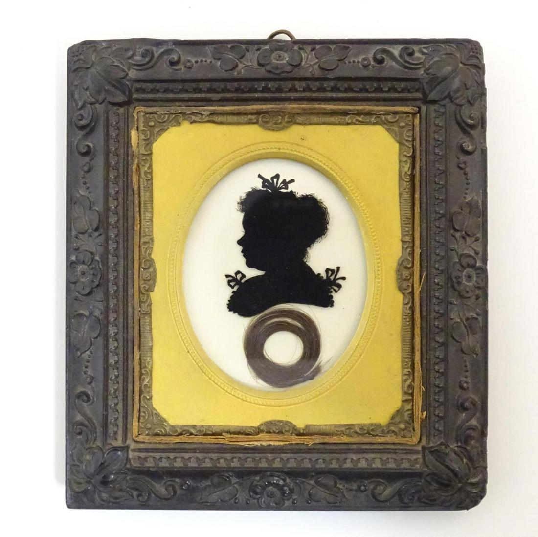A 19thC oval reverse glass silhouette portrait miniature depicting a woman with a bow in her hair (1 of 3)