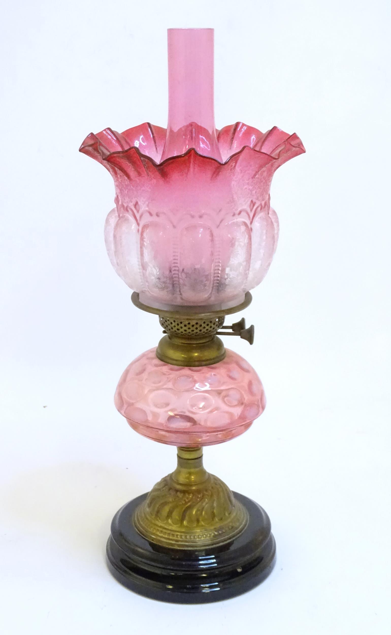 A Victorian Veritas table oil lamp, the circular stepped ceramic base supporting a brass column and (1 of 7)