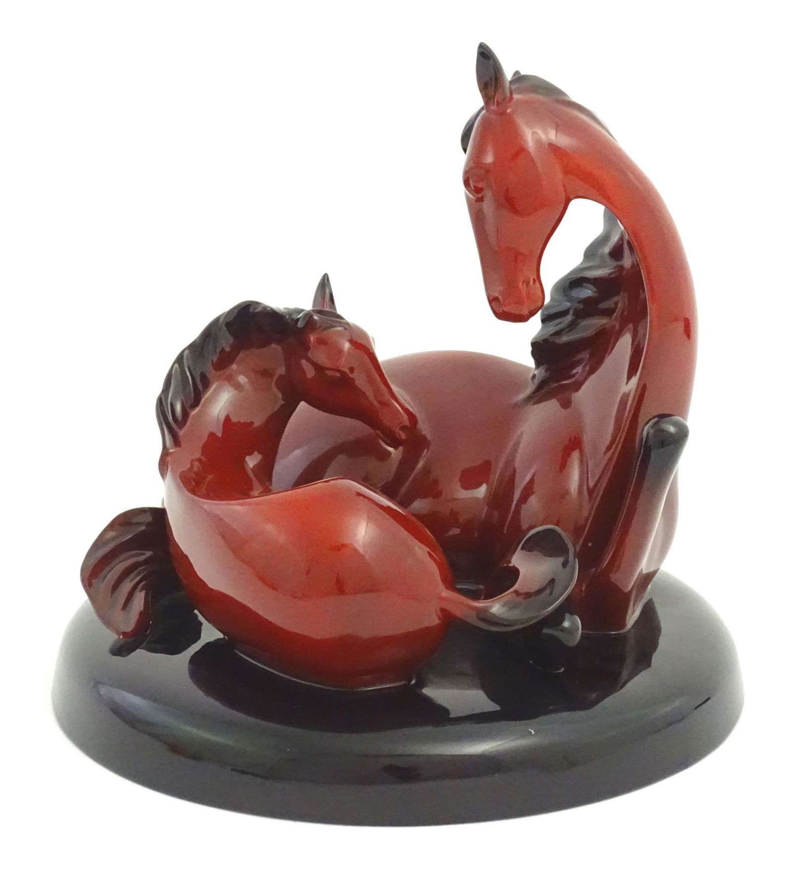 A Royal Doulton flambe model of horses on a circular base, The Gift of Life, Mare and Foal. Marked: A Royal Doulton flambe model of horses on a circular base, The Gift of Life, Mare and Foal. Marked under. Approx. 8 3/4" high Please Note - we do not make reference to the condition of lots within des