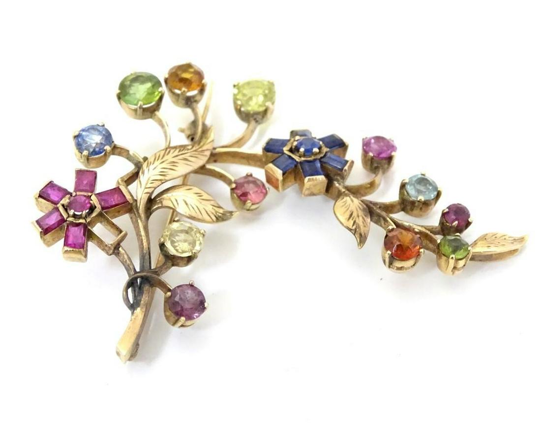 A gold brooch of floral foliate form set with a profusion of semi precious stones including pink, (1 of 5)