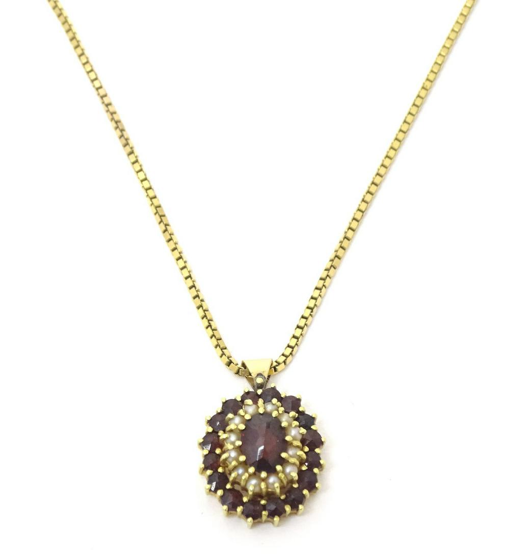 A 9ct gold pendant set with garnet and seed pearls, on a 9ct gold chain. The pendant approx 3/4" (1 of 5)