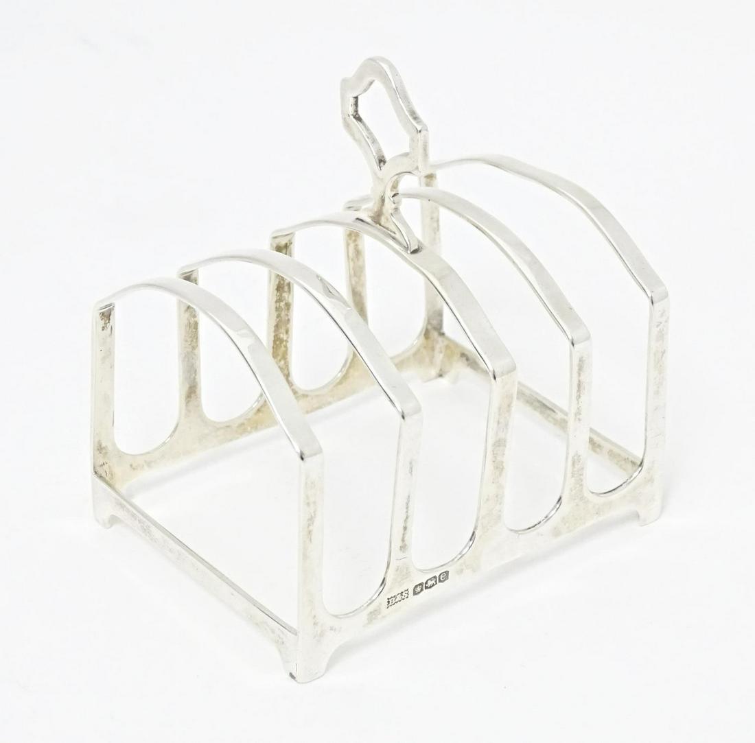 A silver five bar toast rack, hallmarked Sheffield 1922, maker Brook & Son. Approx. 3" longPlease (1 of 9)