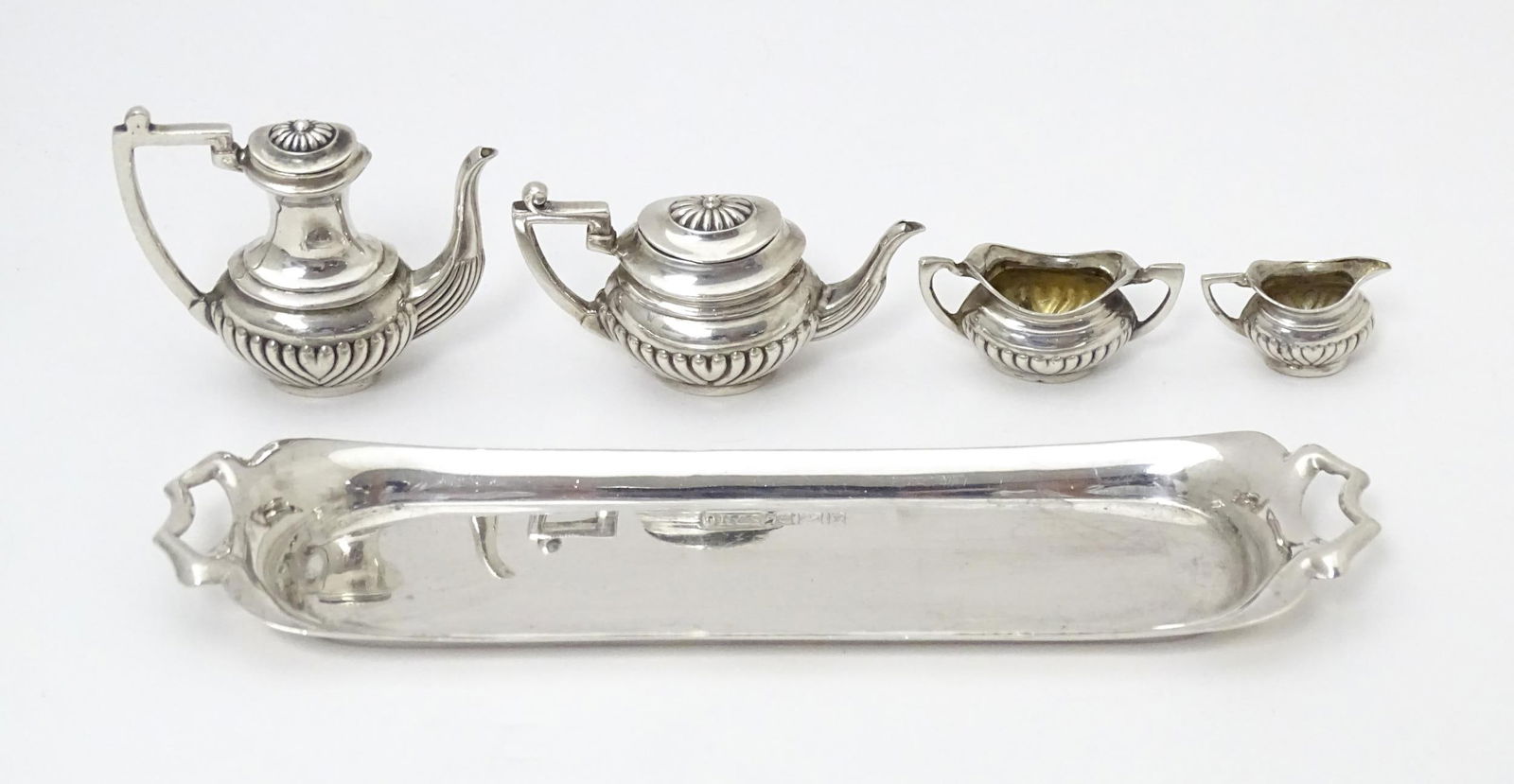 A silver 5 piece miniature / dolls house tea set comprising tea pot, coffee pot, sugar bowl and: A silver 5 piece miniature / dolls house tea set comprising tea pot, coffee pot, sugar bowl and cream jug on a twin handled tray. Hallmarked Birmingham 1972 maker David Hollander & Son. The tray appro
