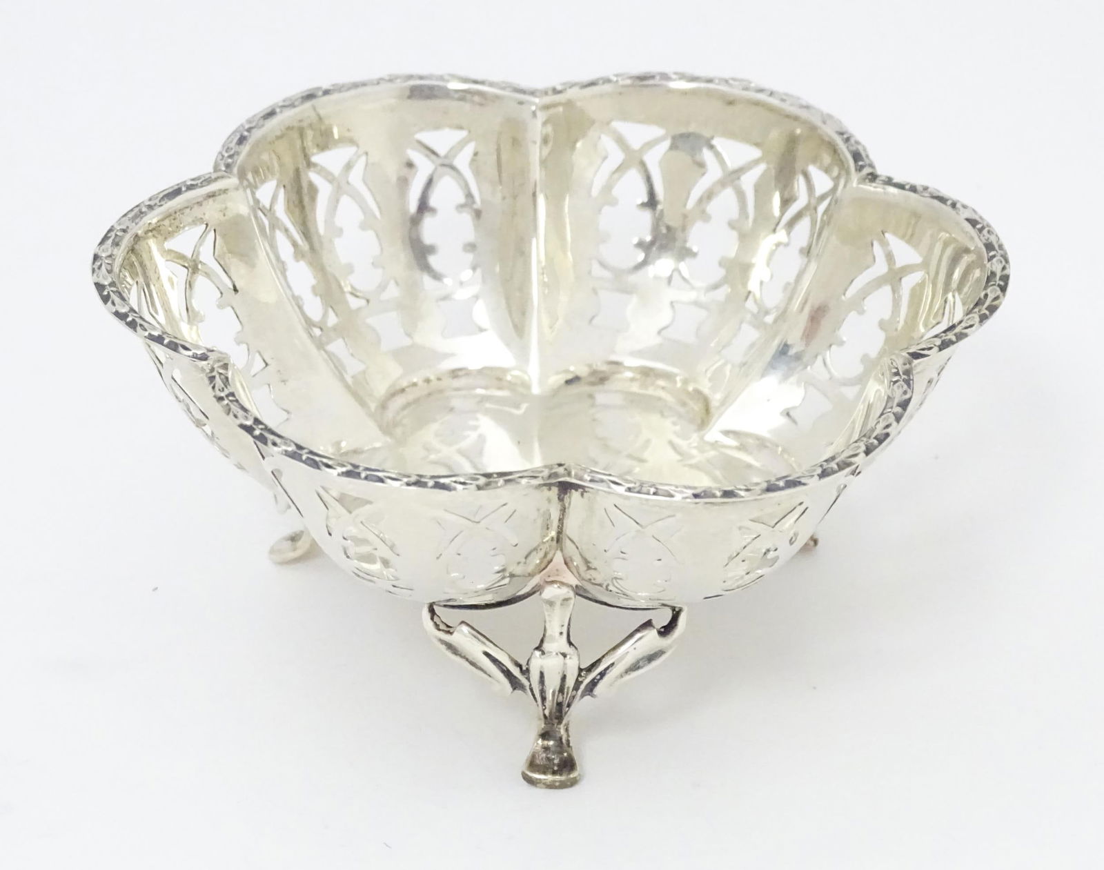 A silver bonbon dish with pierced detail and raised on three out swept feet. Hallmarked Birmingham (1 of 5)