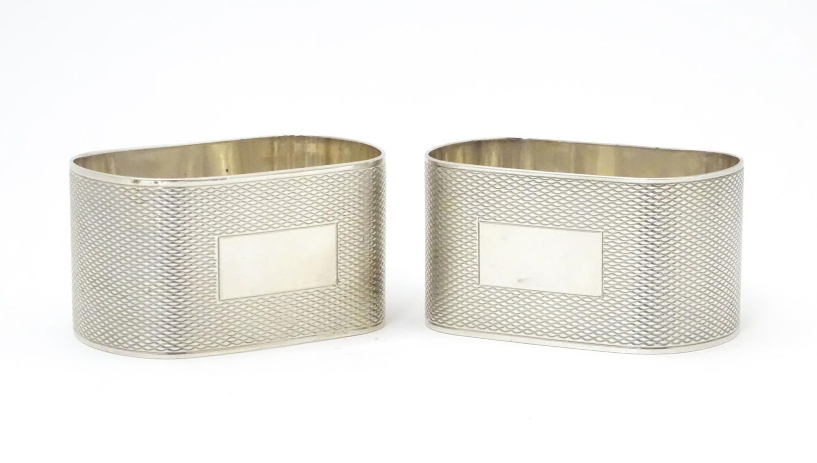 A pair of silver napkin rings of ovoid form with engine turned decoration, hallmarked Birmingham (1 of 6)