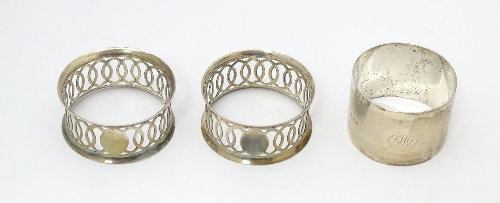 A pair of silver napkin rings with openwork decoration hallmarked Chester 1912, maker M & J. (1 of 9)