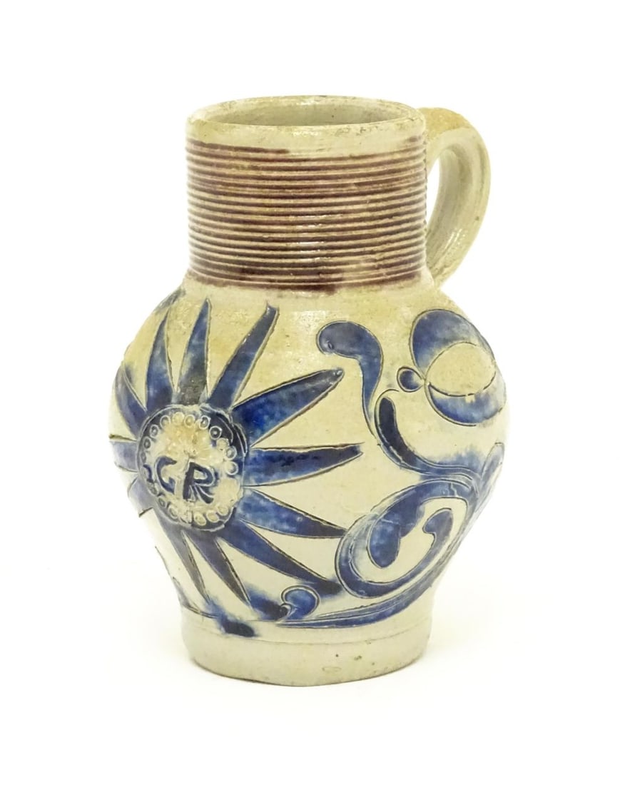 A German Westerwald stoneware jug with single handle, the body with blue painted detail and initials (1 of 6)