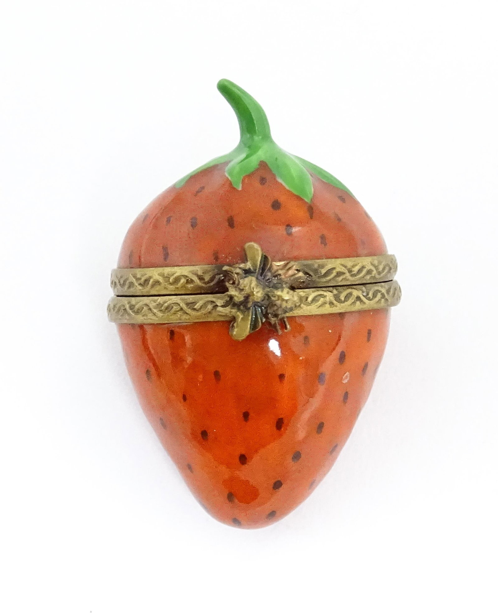 A Limoges pill box modelled as a strawberry with hinged lid, gilt mounts and insect clasp. Marked: A Limoges pill box modelled as a strawberry with hinged lid, gilt mounts and insect clasp. Marked within. Approx. 1 3/4"Please Note - we do not make reference to the condition of lots within descripti