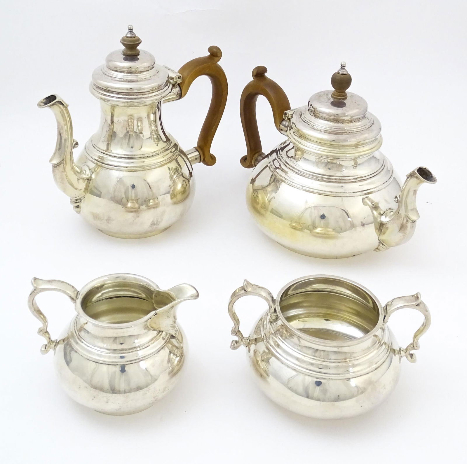 An Elizabeth II silver four piece tea set comprising, teapot, hot water pot, sugar bowl and milk: An Elizabeth II silver four piece tea set comprising, teapot, hot water pot, sugar bowl and milk jug, hallmarked London 1961, maker William Comyns & Sons Ltd. (Richard Comyns). Hot water pot approx. 7