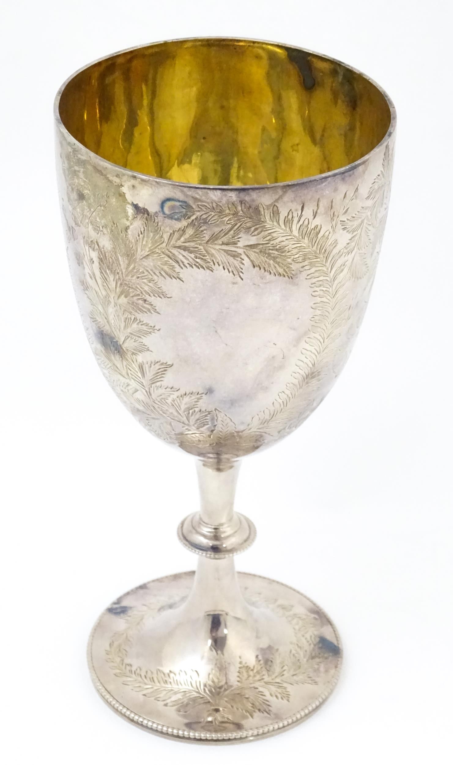 A Victorian silver goblet with engraved fern decoration and gilded interior, hallmarked London 1878,: A Victorian silver goblet with engraved fern decoration and gilded interior, hallmarked London 1878, maker Charles Stuart Harris. Approx. 8 1/4" high Please Note - we do not make reference to the cond