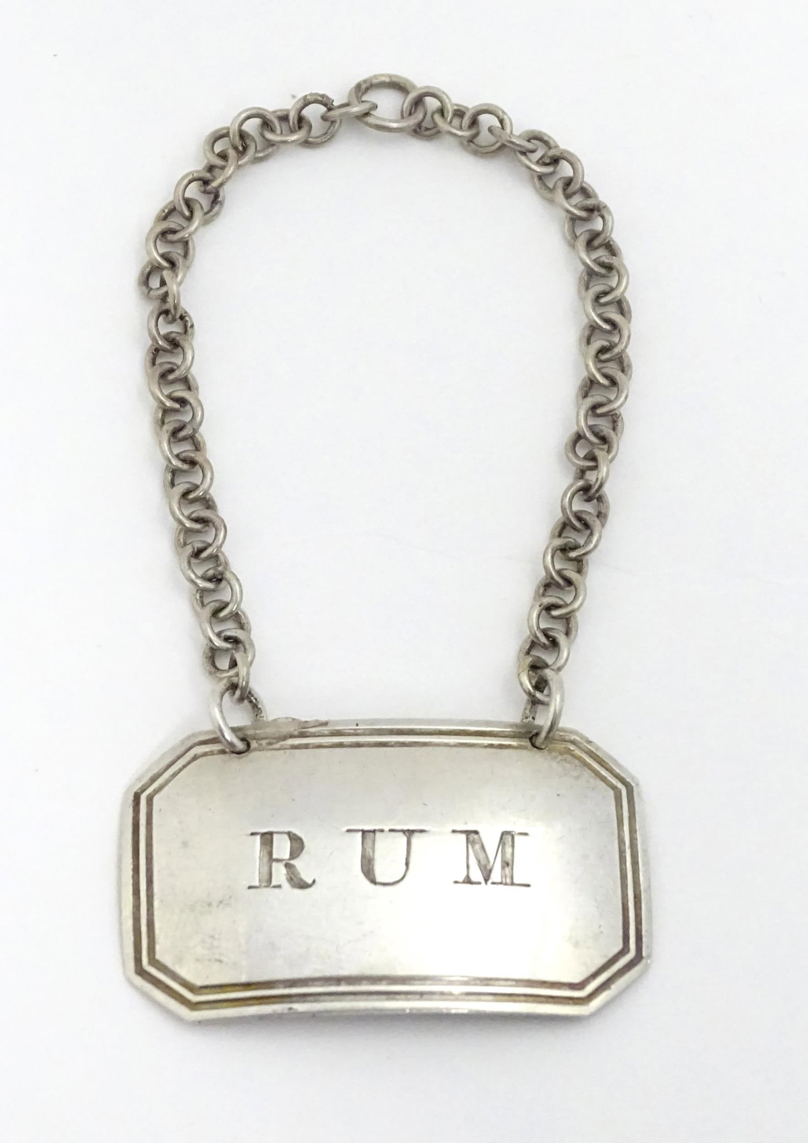 A Geo IV silver decanter / wine label / bottle ticket for Rum hallmarked Birmingham 1824, maker: A Geo IV silver decanter / wine label / bottle ticket for Rum hallmarked Birmingham 1824, maker Joseph Willmore. Approx. 1 3/4" wide Please Note - we do not make reference to the condition of lots wit