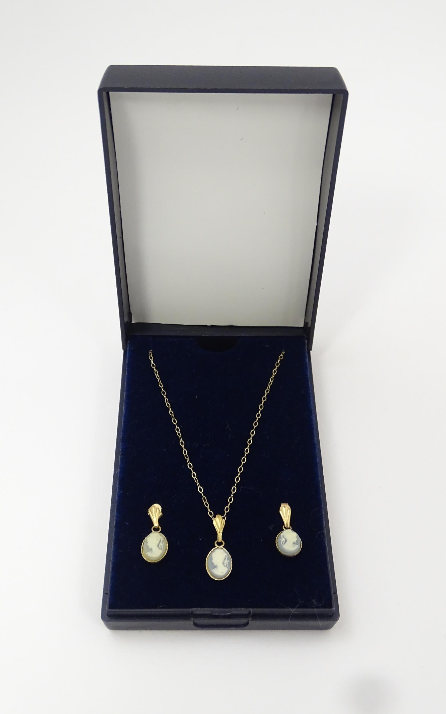 A pair of earrings set with cameo detail. Together with a matching pendant on a 9ct gold chain. The: A pair of earrings set with cameo detail. Together with a matching pendant on a 9ct gold chain. The earrings approx 1/2" long Please Note - we do not make reference to the condition of lots within des