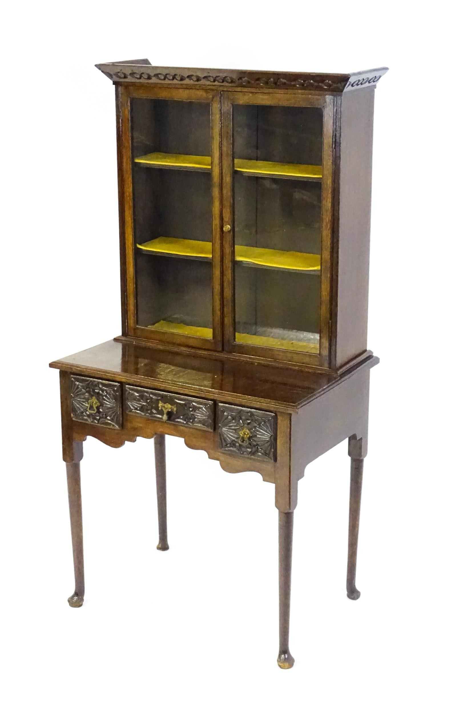 An Early 20thc Oak Lowboy Bookcase, With A Moulded And Carved Cornice