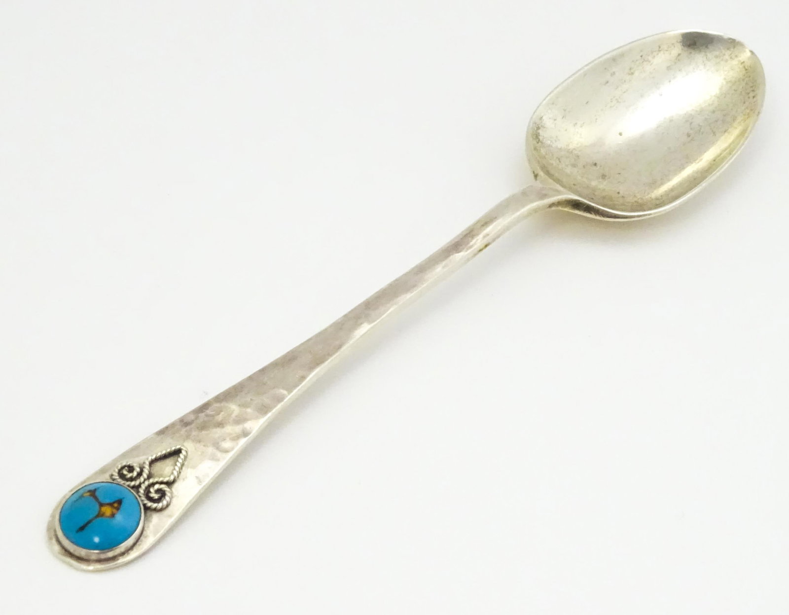 A silver teaspoon with hammered decoration and cabochon detail to handle hallmarked Birmingham 1928,: A silver teaspoon with hammered decoration and cabochon detail to handle hallmarked Birmingham 1928, maker Langstone Silverworks (Bernard Instone). Approx. 4 3/4" longPlease Note - we do not make refe