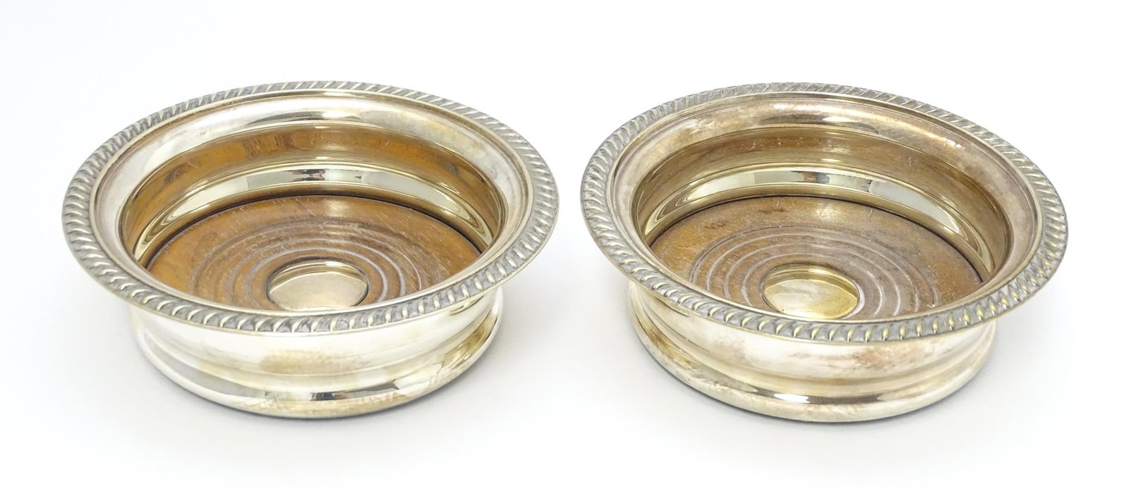 A pair of silver plate coasters with turned wooden bases. Approx. 5 3/4" wide (2) Please Note - we (1 of 5)