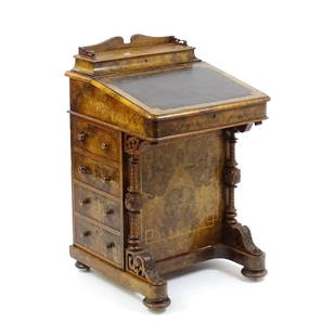 A mid / late 19thC burr walnut Davenport surmounted by a fitted writing box above a leather slope,: A mid / late 19thC burr walnut Davenport surmounted by a fitted writing box above a leather slope, the sides having four short drawers to one side and four opposing sham drawers. The frame having sati