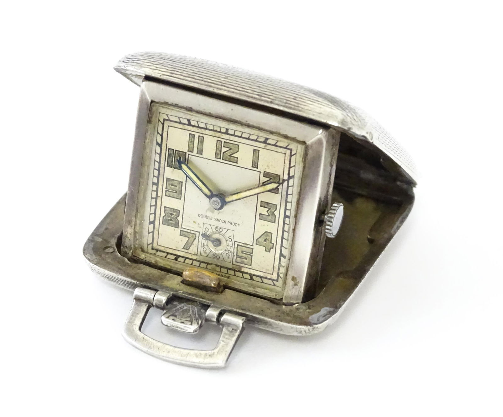 A small travel clock of squared form, the silver case with engraved engine turned decoration, (1 of 8)
