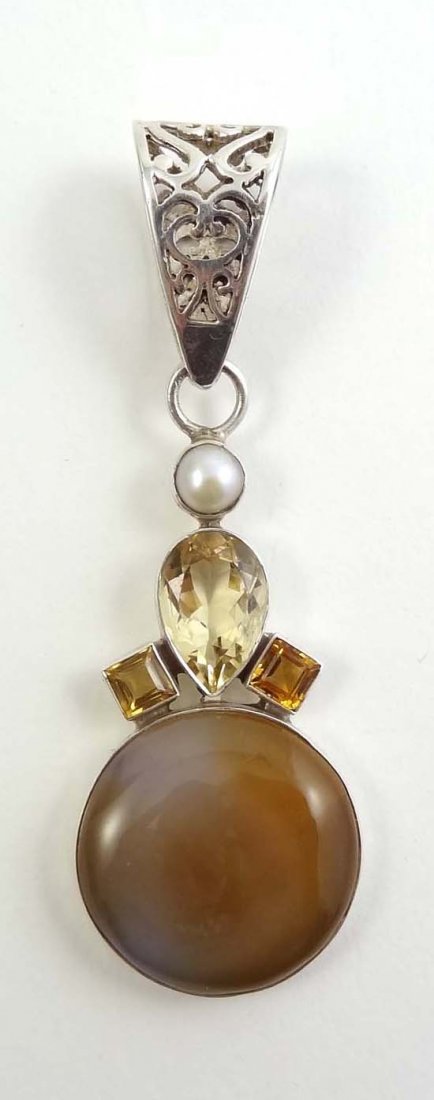 A silver pendant set with circular agate cabachon: A silver pendant set with circular agate cabachon surmounted by lemon topaz and citrines pendant in silver, round agate, lemon topaz, citrines and pearl 3"