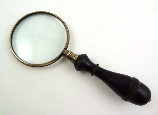 A brass magnifying glass with turned ebonised hand: A brass magnifying glass with turned ebonised handle 6 1/4" long