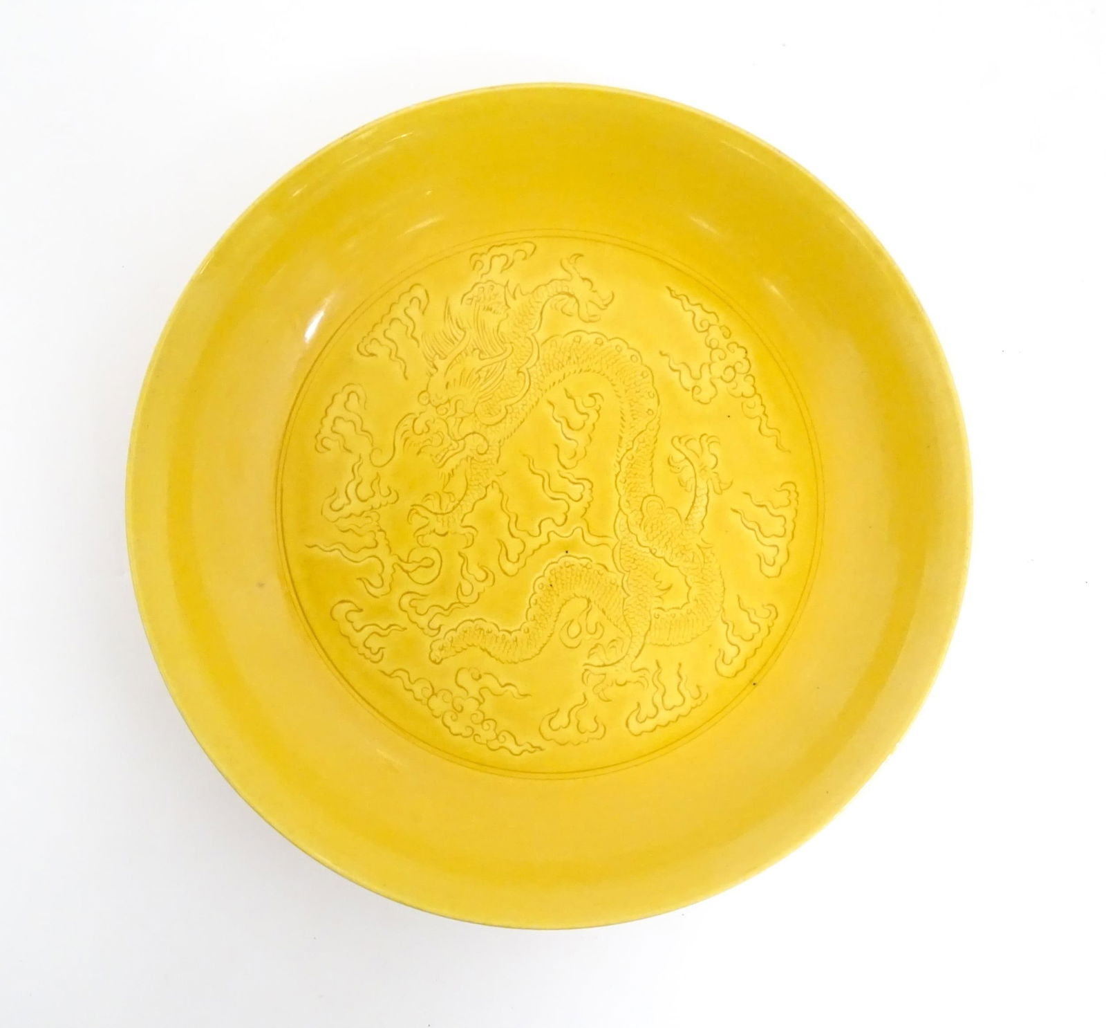 A Chinese dish with a yellow ground decorated with dragons amongst stylised clouds. Character marks: A Chinese dish with a yellow ground decorated with dragons amongst stylised clouds. Character marks under. Approx. 7 1/2" diameter Please Note - we do not make reference to the condition of lots withi