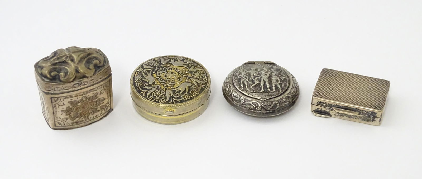 A Dutch silver peppermint box with engraved floral decoration together with a Sterling silver pill: A Dutch silver peppermint box with engraved floral decoration together with a Sterling silver pill box with engine turned decoration and two silver plate hinged lidded boxes. The peppermint box approx