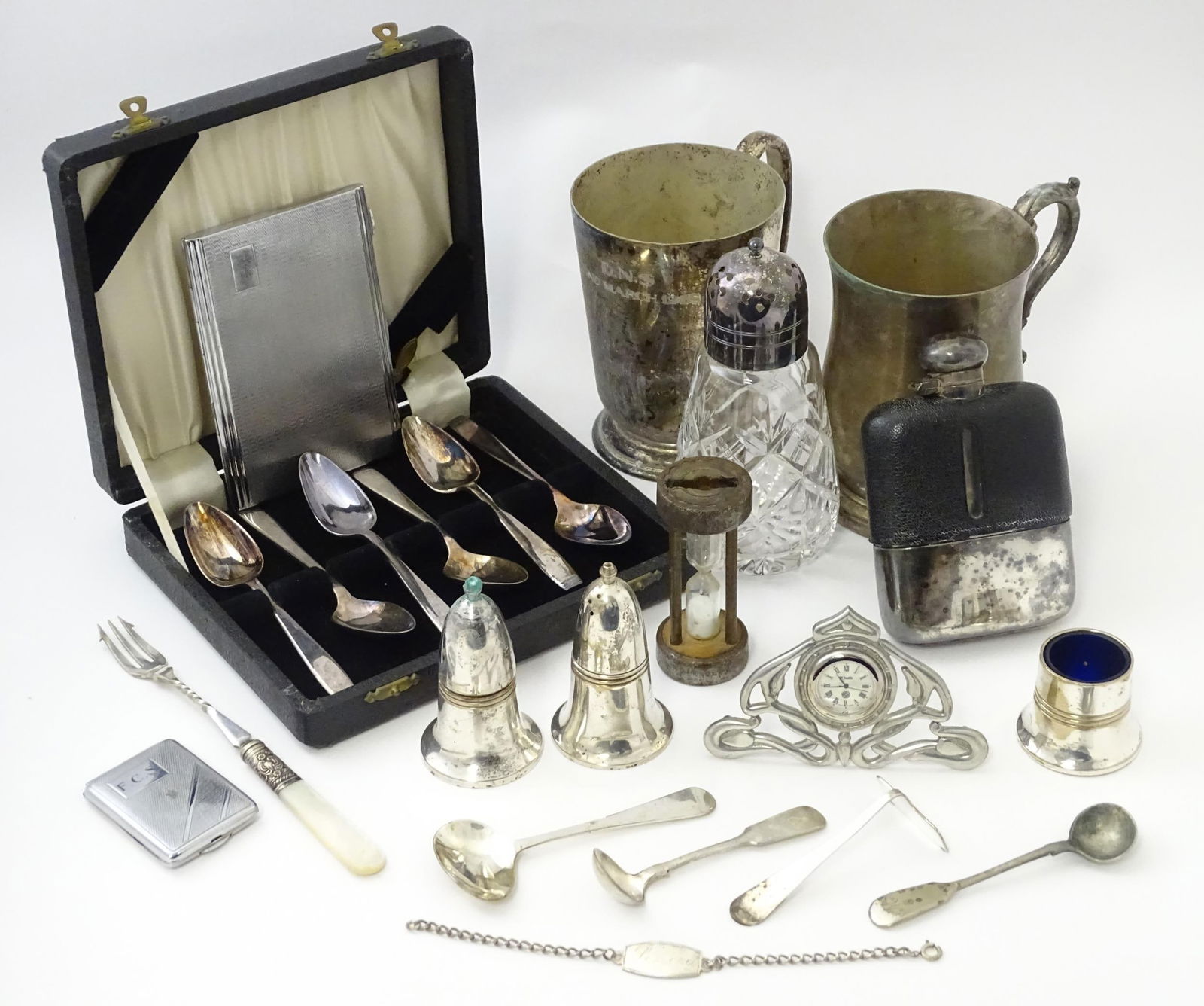 A quantity of silver plate items to include tankards, cruets, cigarette case, match book case,: A quantity of silver plate items to include tankards, cruets, cigarette case, match book case, clock, hip flask, etc. Together with a silver ID bracelet. Largest tankard approx. 5" high Please Note -