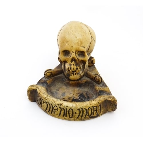 A 20thC composite Memento Mori ashtray with skull and crossed bone detail. Approx. 4" high Please: A 20thC composite Memento Mori ashtray with skull and crossed bone detail. Approx. 4" high Please Note - we do not make reference to the condition of lots within descriptions. We are however happy to