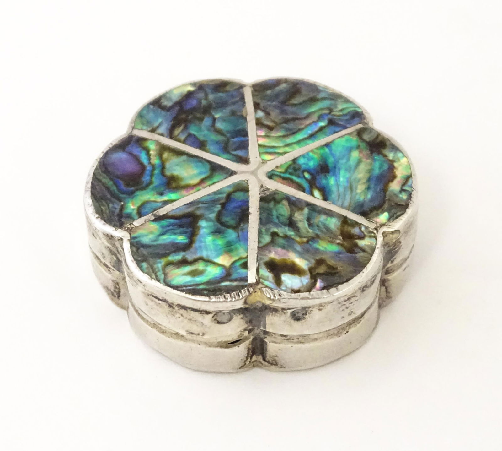 A Mexican silver pill box with inlaid abalone detail. Approx. 1 1/4" wide: A Mexican silver pill box with inlaid abalone detail. Approx. 1 1/4" widePlease Note - we do not make reference to the condition of lots within descriptions. We are however happy to provide additional