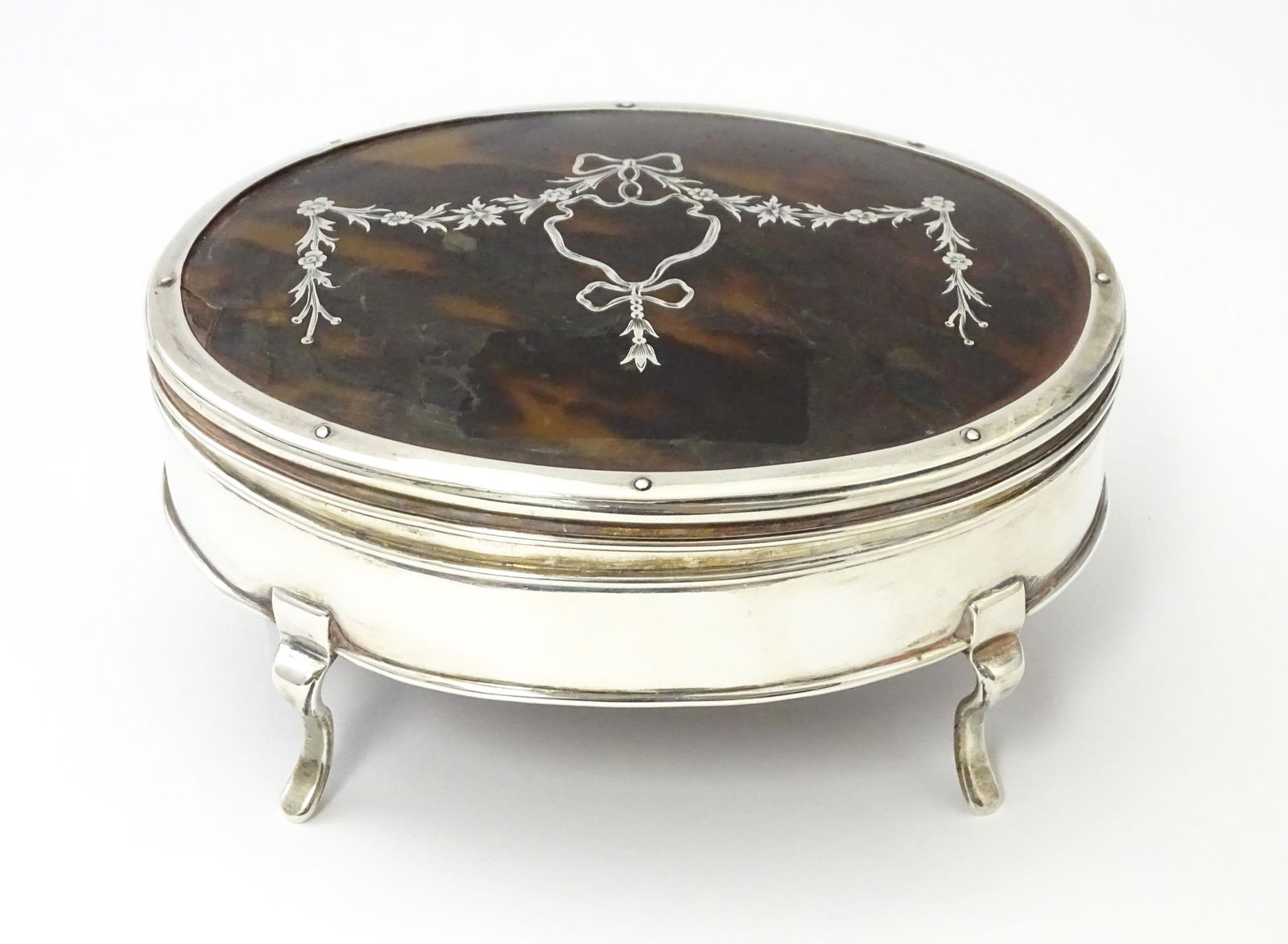 A silver jewellery box of oval form with tortoiseshell and pique work detail to lid, hallmarked: A silver jewellery box of oval form with tortoiseshell and pique work detail to lid, hallmarked London 1917, maker Charles & Richard Comyns. Approx. 5 1/2" widePlease Note - we do not make reference t