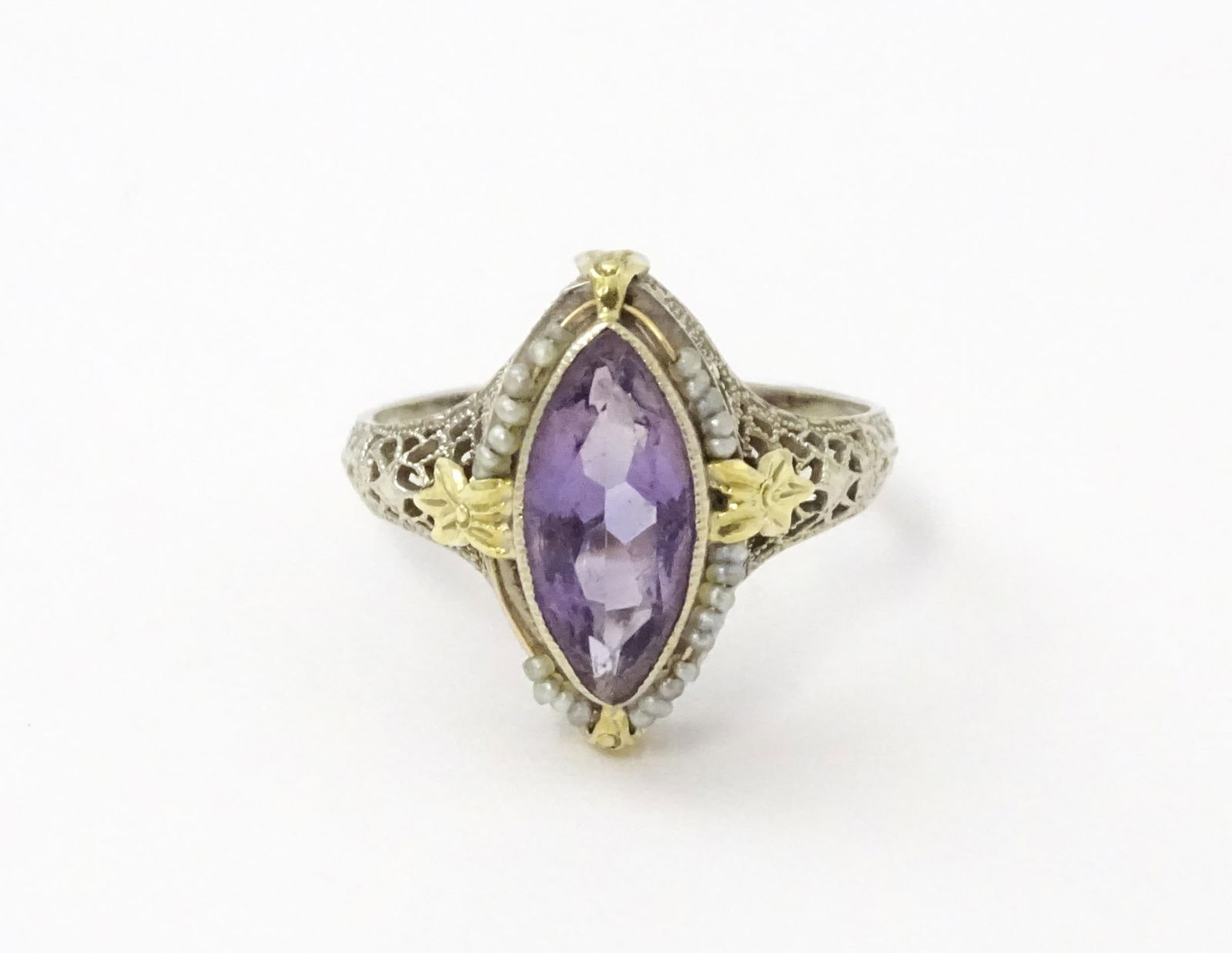 A 14k gold ring set with central amethyst and seed pearls with filigree style detail. Ring size (1 of 11)