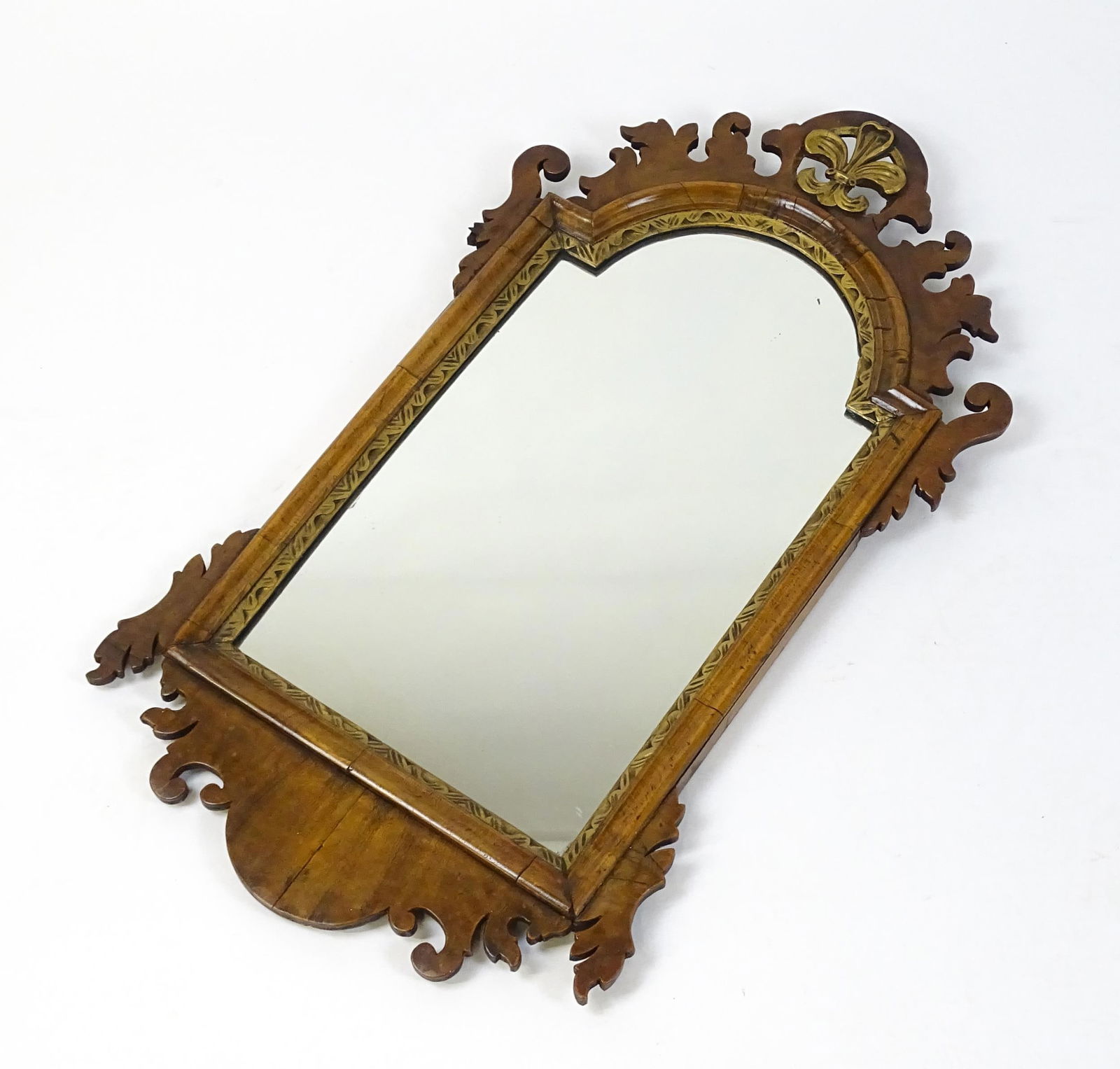 An early 20thC walnut wall mirror surmounted by a gilt Fleur de Lys, carved scrolled decoration and (1 of 6)