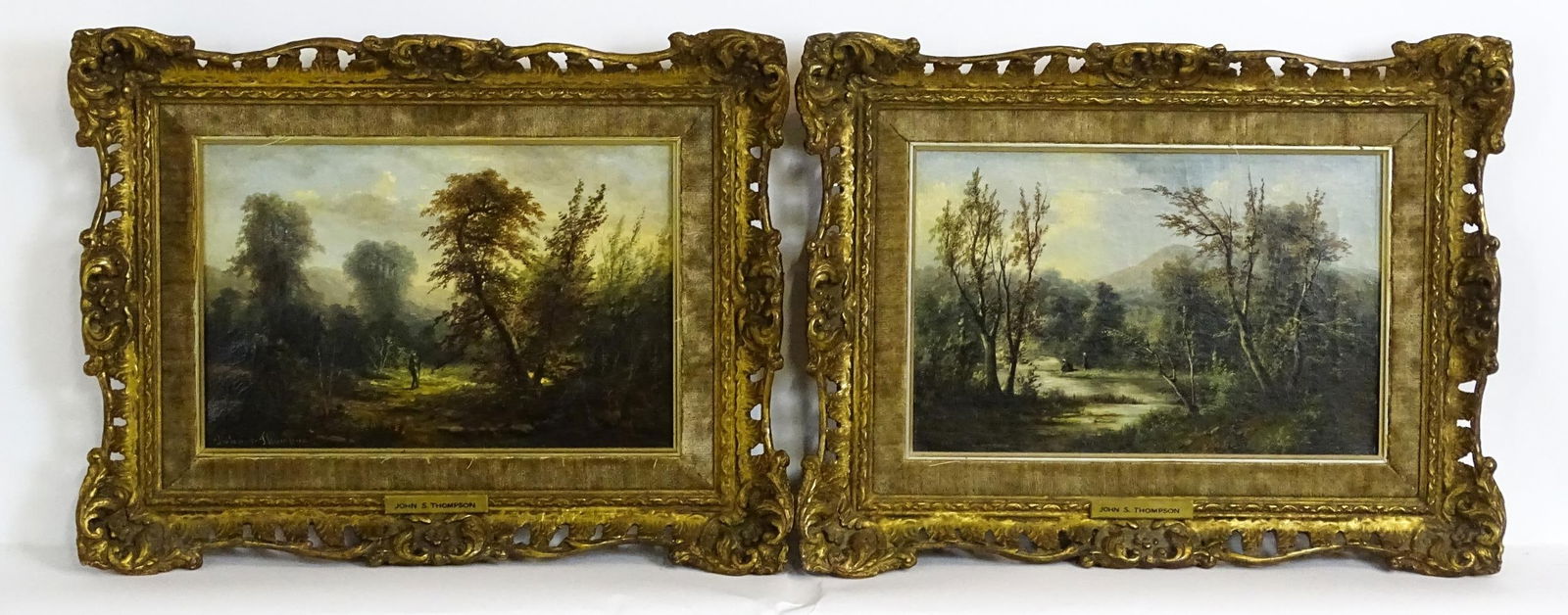 John S. Thompson, 19th century, Oil on canvas, A pair of landscape scenes, one depicting a wooded: John S. Thompson, 19th century, Oil on canvas, A pair of landscape scenes, one depicting a wooded landscape with a figure walking, the other a river scene with figures washing. Both signed lower left.