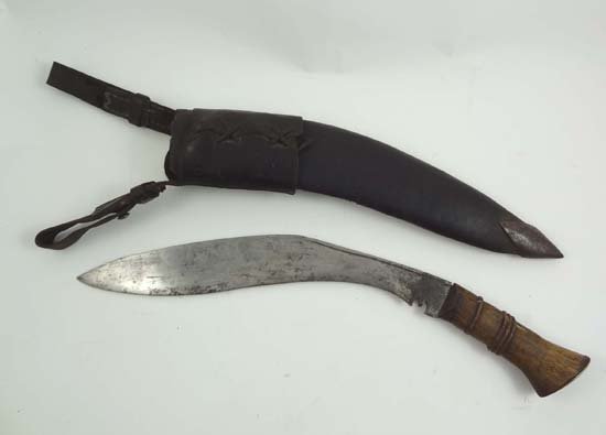 A Nepalese kukri with wooden handle and leather sc: A Nepalese kukri with wooden handle and leather scabbard, the scabbard bears slots for another two smaller blades. Overall length 1 3/4", blade length 12 1/4".