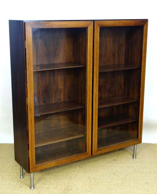 Vintage Retro : a Danish Rosewood glazed front bookcase: Vintage Retro : a Danish Rosewood glazed front bookcase designed by Omann Jun with three adjustable shelves and two glazed cupboard doors standing on four chromed legs 47 1/2" wide and 53"high