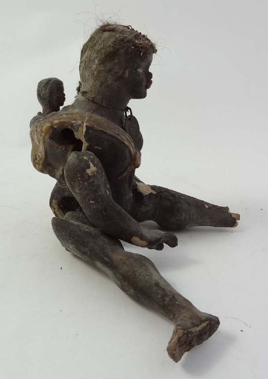 A 19thC painted wooden and papier-mache black doll of a: A 19thC painted wooden and papier-mache black doll of a negro mother carrying her baby on her back, with articulated limbs and human / horse hair to head.