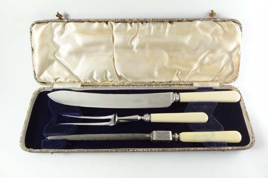 A cased carving set comprising knife , fork and steel w: A cased carving set comprising knife , fork and steel with ivorine handles.