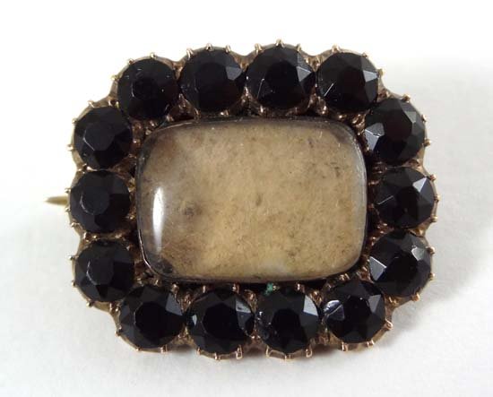 Memorial Jewellery : a yellow metal mourning brooch wit: Memorial Jewellery : a yellow metal mourning brooch with jet bordered and locket like section to centre 3/4" wide