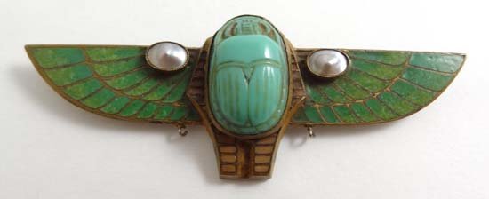 Egyptian Revival Jewellery : A gilt metal brooch with g: Egyptian Revival Jewellery : A gilt metal brooch with green enamel decoration and set with pearl and ceramic scarab beetle decoration 3" wide