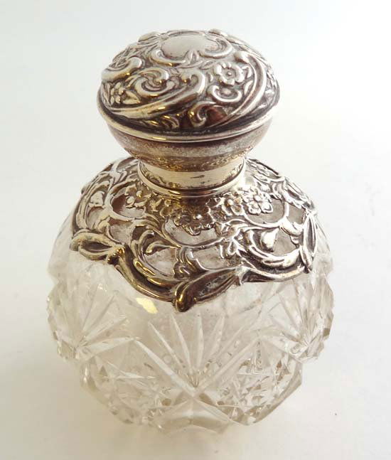 A cut glass scent bottle of spherical form with HM silv: A cut glass scent bottle of spherical form with HM silver mounts and lid. Chester 1909 maker Henry Matthews 4" high