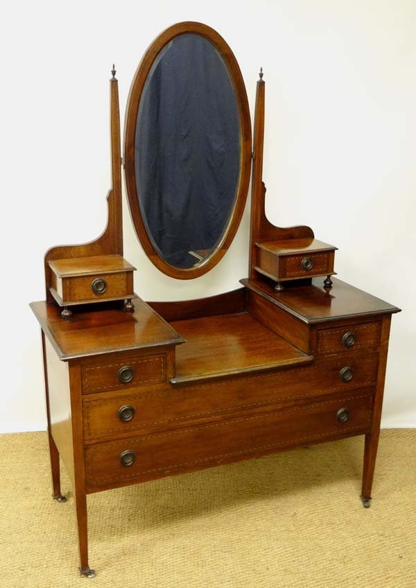 An Edwardian mahogany dressing table with oval bevelled: An Edwardian mahogany dressing table with oval bevelled hinged mirror 44 1/2" wide