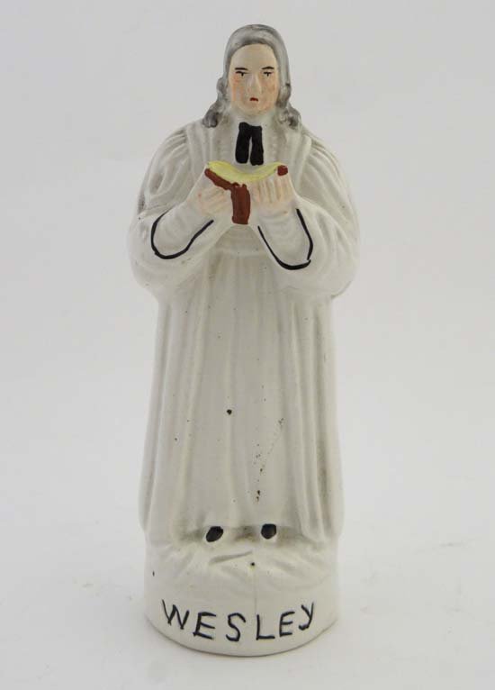 A Victorian Staffordshire figure entitled Wesley,: A Victorian Staffordshire figure entitled Wesley, depicting John Wesley, considered to be the founder of the Methodist movement, holding an open bible. Height 7"