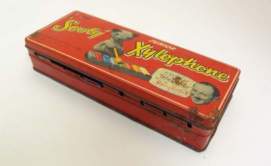 A c1950s Sooty Junior Xylophone in original tin box, as: A c1950s Sooty Junior Xylophone in original tin box, as featured on television by Harry Corbett, also contains sticks and instructions. 8 1/4" long.