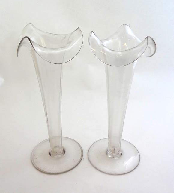 A pair of 19thC clear glass pedestal epergnes with wavy: A pair of 19thC clear glass pedestal epergnes with wavy rim decoration 11" high £30 - 40