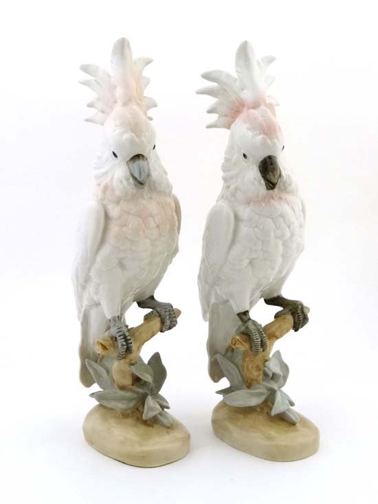 A large pair of Royal Dux Cocka' toos decorated in: A large pair of Royal Dux Cocka' toos decorated in white, pink and green glazes, perched upon branches. Royal Dux stamp to base. Each 16" tall. (2) £100 - 150