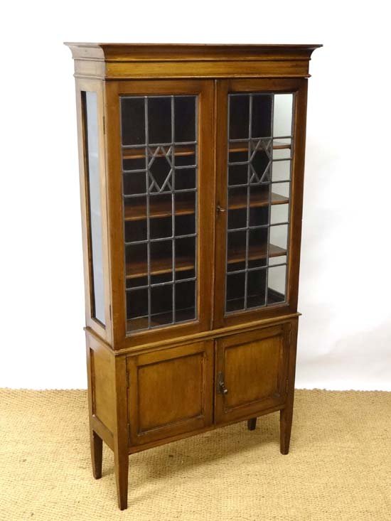 An Edwardian stained mahogany leaded glazed bookcase /: An Edwardian stained mahogany leaded glazed bookcase / display case with 2-door cupboard under. 31 1/4" wide x 60 1/2" high £60 - 90